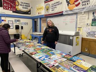 woman standing in front of childrens books