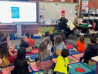 police officer reading to school children